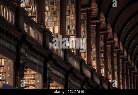 Vintage-Bibliothek mit Regalen von alten Büchern im Langen Raum im Trinity College. Dublin, Irland - 15. Februar 2014 Stockfoto