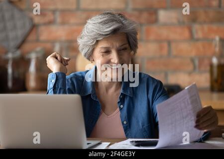 Glücklich reifen latein weiblich Lesung Finanzbericht zufrieden mit Ergebnis Stockfoto