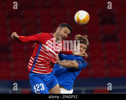 BUDAPEST, UNGARN - 18. MÄRZ: Jorge Molina aus Granada CF kämpft mit Martin Bjornbak vom FK Molde während des UEFA Europa League Round of 16 Second Leg Match zwischen Molde und Granada in der Puskas Arena am 18. März 2021 in Budapest, Ungarn um den Ball in der Luft. Sportstadien in ganz Europa unterliegen aufgrund der Coronavirus-Pandemie strengen Beschränkungen, da staatliche Gesetze zur sozialen Distanzierung Fans in Veranstaltungsorten verbieten, was dazu führt, dass Spiele hinter verschlossenen Türen gespielt werden. Stockfoto