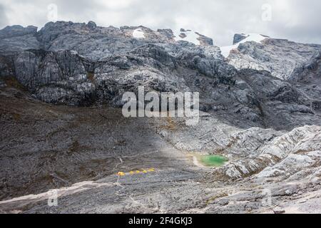 Camping Zelte in der Carstensz Pyramide (Puncak Jaya) Höhenbasislager mit grün-blauem See Stockfoto