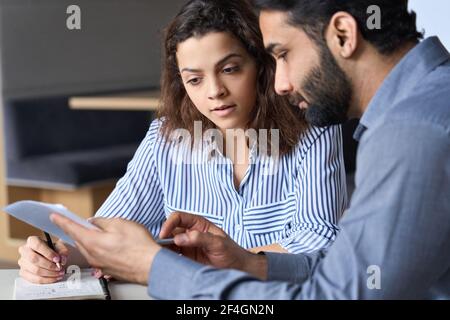 Indischer Lehrer Manager diskutiert Papiere mit latein-Schüler, Kunde bei der Sitzung. Stockfoto