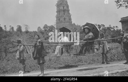 Zwei westliche Frauen in Sedan Stühlen, Leifeng Pagode im Hintergrund, China, Hangzhou (China), Zhejiang Sheng (China), 1908. Aus der Sammlung Sidney D. Gamble Photographs. () Stockfoto