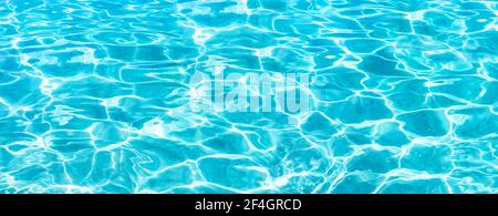 Leuchtendes blaues Wasser Welligkeit Hintergrund. Wasseroberfläche im Schwimmbad. Tropischer Strand Wasser Hintergrund. Stockfoto