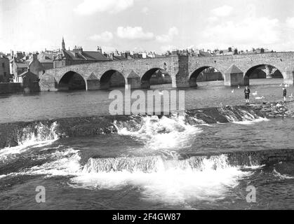 1951, historisch, Blick auf den Fluss Nith der Devorgilla Bridge, einer alten Brücke in Dumries, Schottland, Großbritannien. Diese 6-spannige Bogenbrücke, auch bekannt als Devorgilla's Bridge, ist eine der ältesten stehenden Brücken Schottlands. Es hatte ursprünglich neun Bögen, aber drei wurden im Jahr 1794 weggenommen, als es wieder aufgebaut wurde. Stockfoto