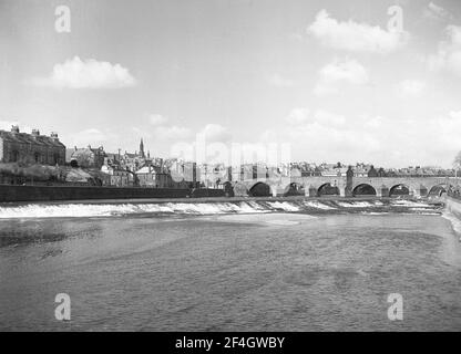 1951, historisch, Blick auf den Fluss Nith der Devorgilla Bridge, einer alten Brücke in Dumries, Schottland, Großbritannien. Diese 6-spannige Bogenbrücke, auch bekannt als Devorgilla's Bridge, ist eine der ältesten stehenden Brücken Schottlands. Es hatte ursprünglich neun Bögen, aber drei wurden im Jahr 1794 weggenommen, als es wieder aufgebaut wurde. Stockfoto