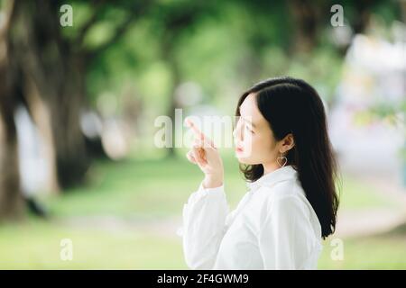 Portrait von asiatischen Mädchen mit weißem Hemd und Rock zeigen Im Outdoor Natur Vintage Film Stil Stockfoto