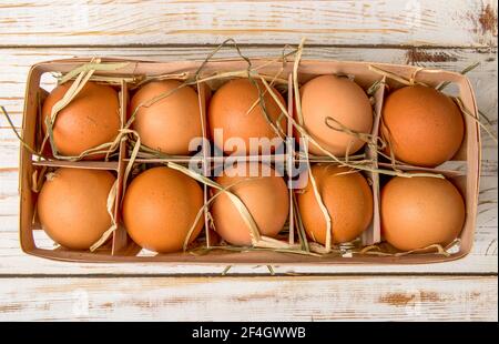 Weideneierschale voll mit frischen Eiern auf einem hölzernen Tabelle Stockfoto