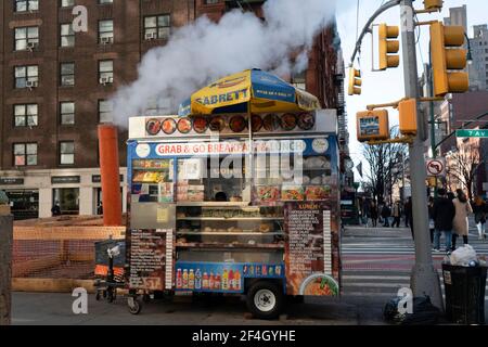 Ein Verkäufer an der Ecke der Seventh Avenue und 14th Street in Manhattans Greenwich Village hat ein Schild auf seinem Wagen, das besagt, dass er Halal-Lebensmittel verkauft. Stockfoto