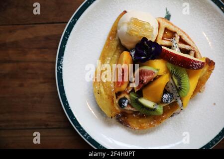 Dessert gebackene Waffeln mit Früchten Kiwo Traube und Vanille Eis im Vintage-Stil Stockfoto