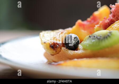 Dessert gebackene Waffeln mit Früchten Kiwo Traube und Vanille Eis im Vintage-Stil Stockfoto