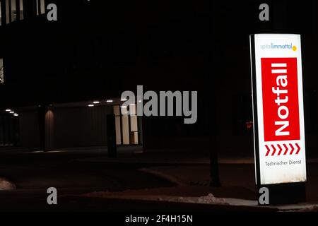 Notaufnahme des Limmattalspitals in Schlieren, Schweiz, nachts in deutscher Sprache geschrieben. Der Wegweiser leuchtete hell auf. Stockfoto