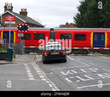 21. März 2021 - Berks, England: Zug fährt durch Bahnüberfahrt Auto wartet Stockfoto