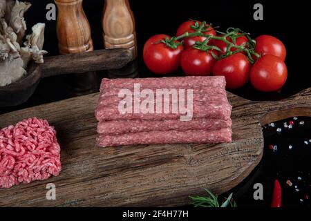 Türkisch Tekirdag oder Inegol Kofte. Rohes Rindfleisch Fleischbällchen mit verschiedenen hausgemachten würzigen, Rindfleisch kofta kofta roh, auf schwarzem Boden. Stockfoto