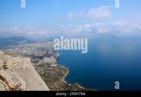 Sonniger Blick vom Berg Sokol auf die Buchten und das Dorf Sudak am Schwarzen Meer auf der Krim. Stockfoto