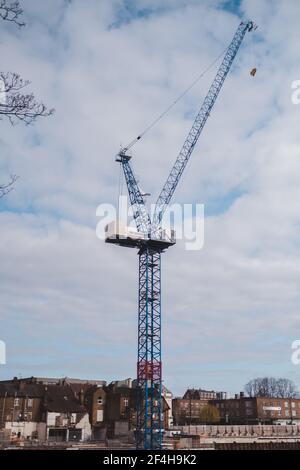 Brentford, West London - 2021,03.21: Kranbau und Bau gegen blauen Himmel neben dem Grand Union Canal Stockfoto