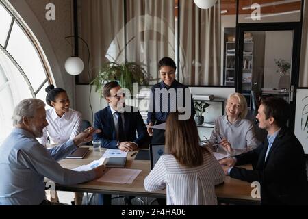 Lächelnde, multiethnische Kollegen führen bei einem Gruppentreffen ein Brainstorming durch Stockfoto