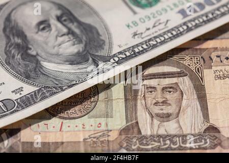 Ein alter Riyal von Saudi-Arabien und 100 US-Dollar Banknoten für Designzwecke Stockfoto