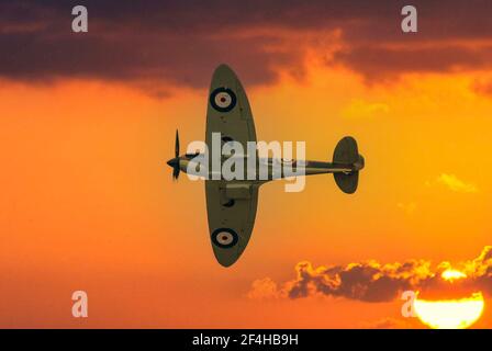 Eine einfarbige Supermarine Spitfire Mk IIa gegen einen orangen Himmel Bei Sonnenuntergang Stockfoto