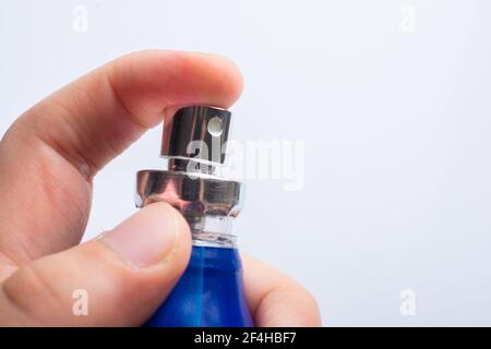 Drücken Sie die Taste, indem Sie die blaue Desinfektionsflasche aufsprühen. Schutz vor Viren, Gesundheitskonzept. Stockfoto