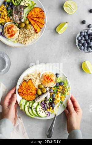 Draufsicht auf Teller mit köstlichem frischen Apfel und Limette Scheiben in der Nähe von Süßkartoffelkeilen und Oliven mit Hummus auf Tabelle Stockfoto