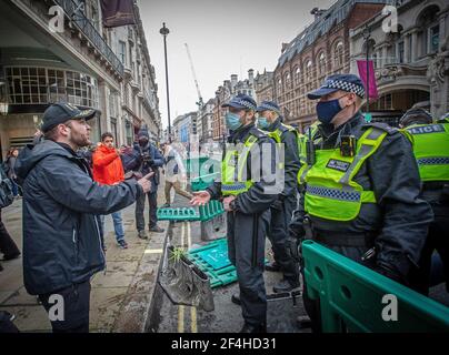 London, Großbritannien. März 2021, 20th. Ein Protestierender und ein Polizist treten während der Demonstration ins Gesicht.Tausende Demonstranten nehmen an einer Anti-Lockdown-m Teil Stockfoto