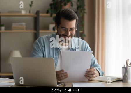 Nahaufnahme lächelnder Geschäftsmann trägt eine Brille und liest gute Nachrichten Stockfoto