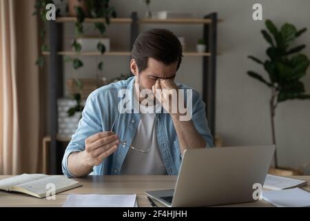 Müde Geschäftsmann massieren Nasenbrücke, Gefühl der Augenbelastung, halten Brille Stockfoto