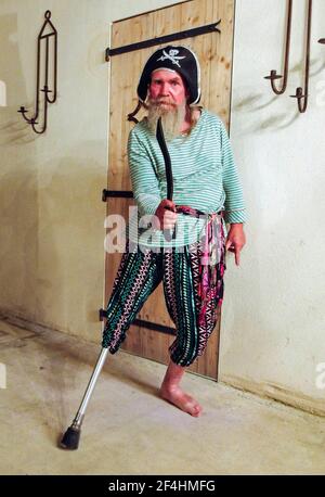 Älterer bärtiger Mann fehlt unten rechts Bein mit seiner Behinderung als Pirat verkleiden. Stockfoto