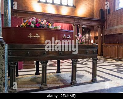 Sarg und Blumen in West Chapel, Golders Green Krematorium, London, Großbritannien. Stockfoto