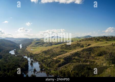 Shepherds Lookout Canberra - Blauer Himmel, weiße Wolken. Grüne Berge mit Fluss dazwischen Stockfoto