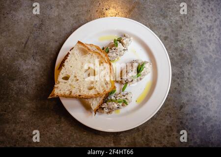 Hering Forshmak mit Weizenbrot auf Teller Stockfoto