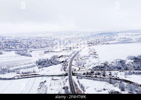 High-Angle-Luftaufnahme Drohne Bild auf der Straße Trog Die Bäume und der Wald in den Bergen mit Weiß bedeckt Schnee am Wintertag in der Nähe von Knjazevac in S Stockfoto