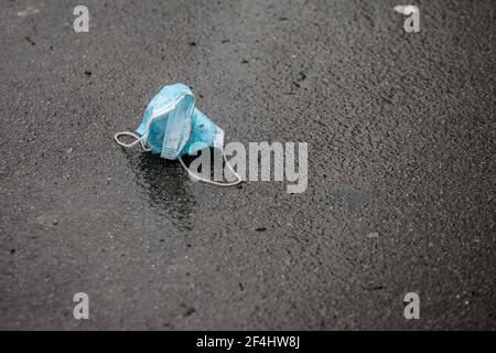 Gebrauchte Gesichtsmaske, Einweg, auf den Boden in der Umwelt als Müll während der Corovavirus covid 19 Krise geworfen. Werfen verwendet Gesicht protecti Stockfoto