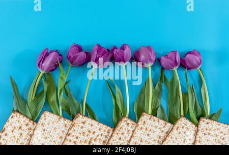 Matzos und Blumen auf dem blauen Hintergrund. Passah (Pesach) Seder Stockfoto