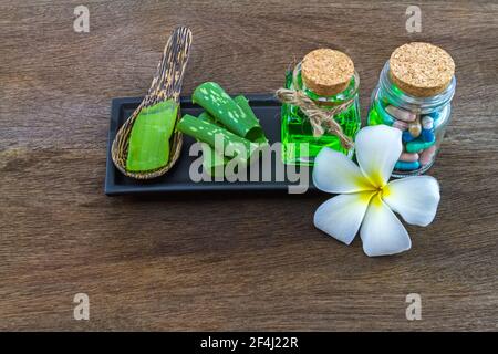 Spa Kräuter (weiße Frangipani Blumen, Pille, Aloe Vera ätherisches Öl und Gel) auf Holzhintergrund Stockfoto