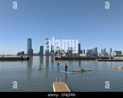New York, USA - März 21 2021: Eine Gruppe von Menschen auf Kajaks und Paddle Boards auf dem Hudson River mit Blick auf New Jersey Stockfoto