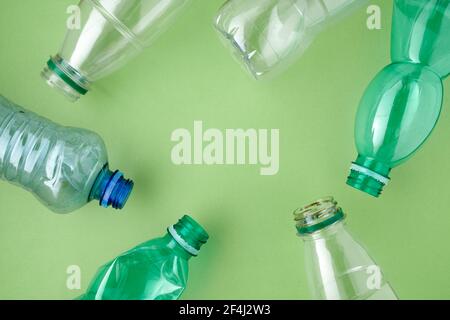 Flach legen mit Plastikflaschen isoliert auf grünem Hintergrund. Stockfoto