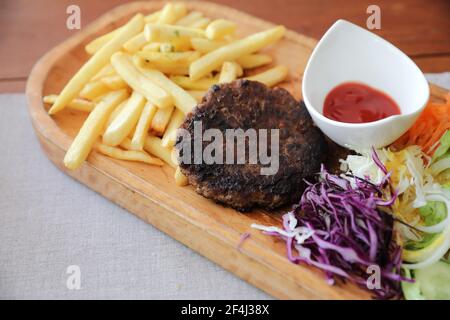 Rinderschnitzel für Steak mit Feuer und Gemüse auf Holz Hintergrund Stockfoto