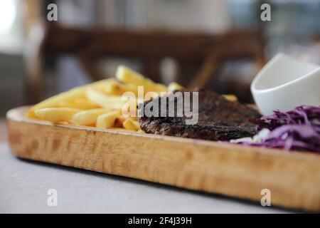 Rinderschnitzel für Steak mit Feuer und Gemüse auf Holz Hintergrund Stockfoto