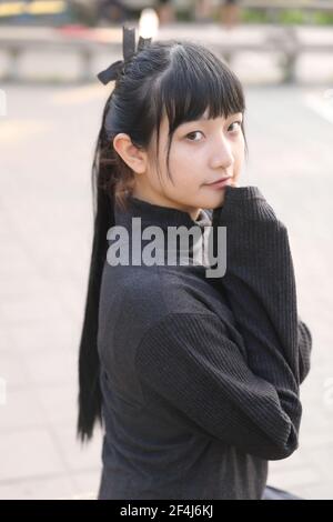 Portrait der asiatischen japanischen Schule Mädchen Kostüm Blick auf Park Outdoor-Film im Vintage-Stil Stockfoto