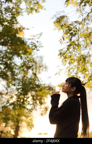 Portrait der asiatischen japanischen Schule Mädchen Kostüm Blick auf Park Outdoor-Film im Vintage-Stil Stockfoto