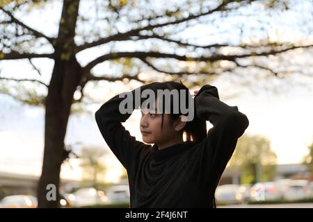 Portrait der asiatischen japanischen Schule Mädchen Kostüm Blick auf Park Outdoor-Film im Vintage-Stil Stockfoto