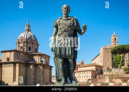 Alte Statue von Julius Caesar in Rom mit Santi Luca E Martina Kirche im Hintergrund Stockfoto