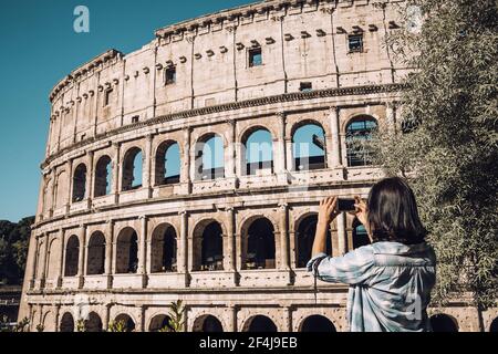 Junge Frau machen ein Foto von Colosseum mit dem Smartphone in Rom Stockfoto