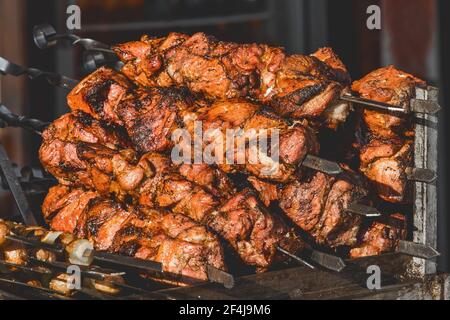 Gebratenes Kebab-Fleisch auf Spiessen in einem Straßenbetrieb, Nahaufnahme. Stockfoto