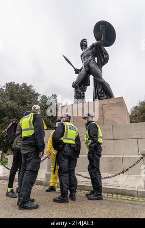 Protestierende werden während eines Anti-Lockdown-Protestes an der Achilles Statue im Hyde Park verhaftet.eine große Zahl von Demonstranten versammelten sich in Zentral-London, um gegen die Anwendung von Sperren in Großbritannien und die Umsetzung des Police Bill zu protestieren. Die Demonstration markiert ein Jahr seit dem Eintritt des Vereinigten Königreichs in seine erste Sperre, die für "drei Wochen geplant war, um die Kurve zu glätten und den NHS zu schützen". Die konservative Regierung ist unter großem Druck der Öffentlichkeit geraten, die Sperren zu beenden, trotz der Befürchtungen, dass Coronavirus-Fälle zunehmen könnten. Die Demonstration wird 10 Downing Street alarmiert haben, die t fürchten würde Stockfoto