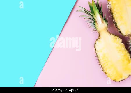 Schneiden Sie die Hälften der frischen Ananas auf pastellrosa und blauen Hintergrund. Exotische Früchte Stockfoto