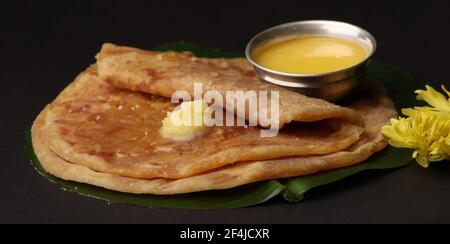 Puran Poli, auch bekannt als Holige, ist ein indisches süßes Fladenbrot aus Indien, das meistens während des Holi-Festivals konsumiert wird. Serviert auf Bananenblatt mit reinem Ghee o Stockfoto