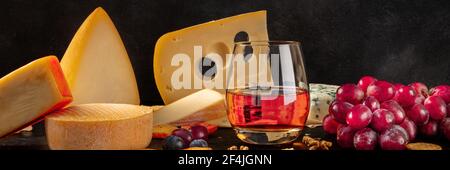 Käse, Wein und Trauben Panorama auf schwarz Stockfoto