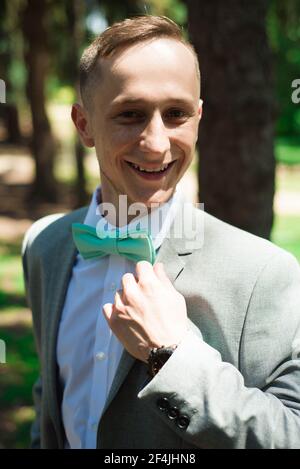 Bräutigam bei Hochzeit Smoking lächelnd und wartet auf Braut. Reicher Bräutigam am Hochzeitstag. Eleganter Bräutigam in Kostüm und Fliege Stockfoto